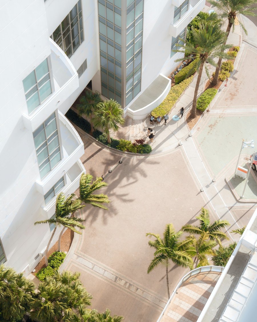 Aerial view of white apartment buildings and palm trees