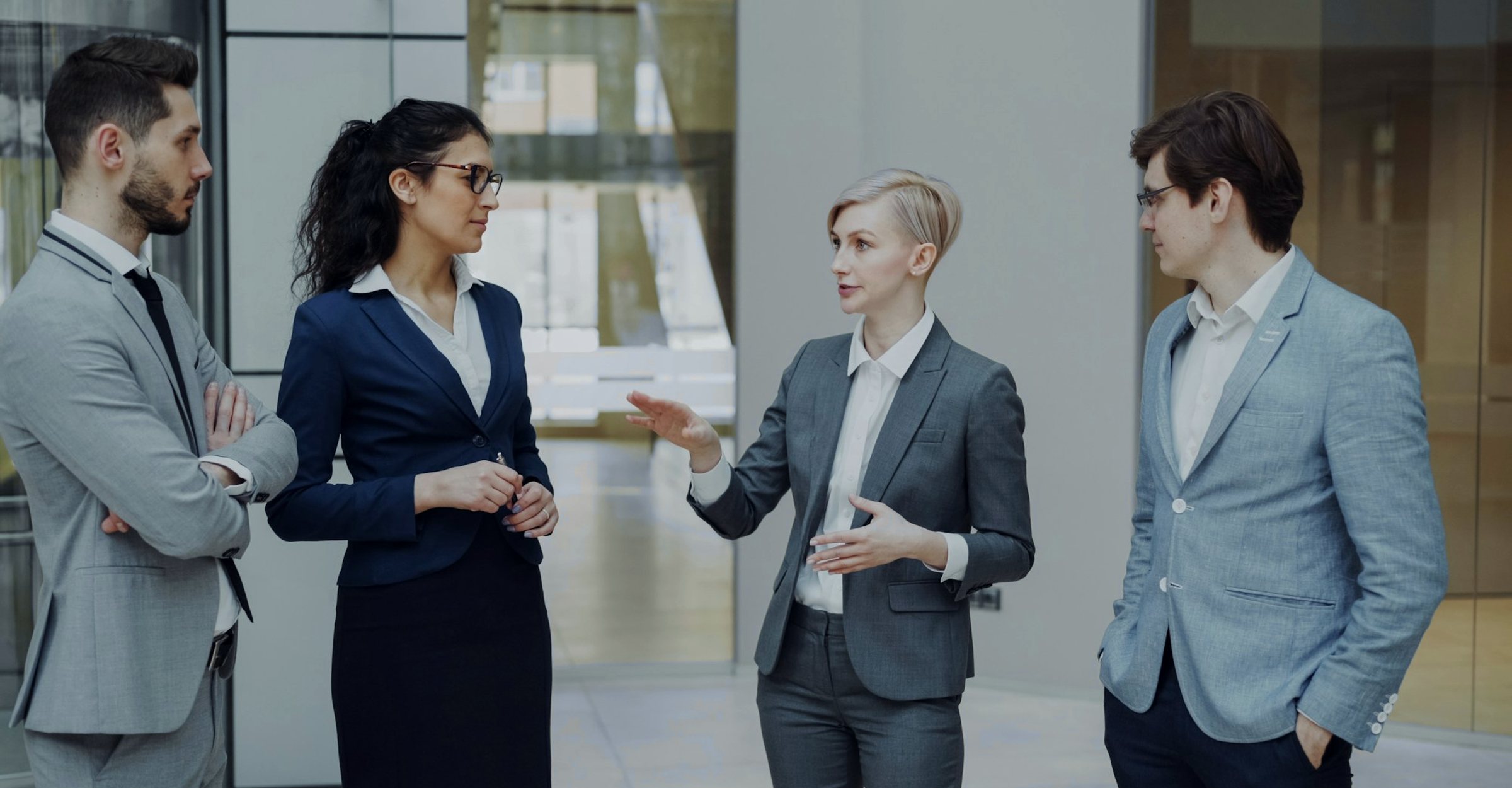 Four colleagues in conversation in an office lobby
